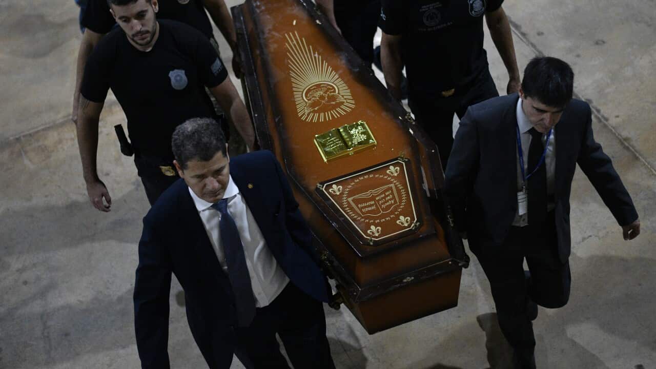 Brazilian police officers carry a coffin