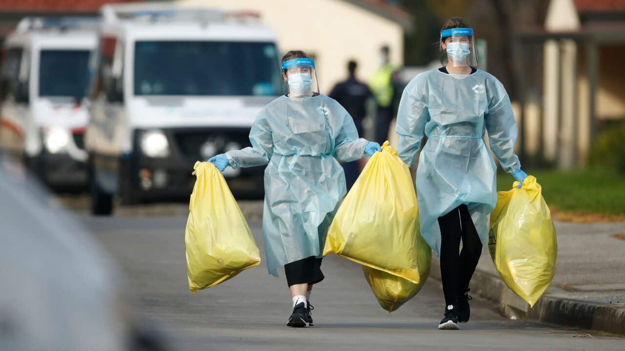 Medical staff with bags of clinical waste is seen at St. Basil's Homes for the Aged in Fawkner, Melbourne.
