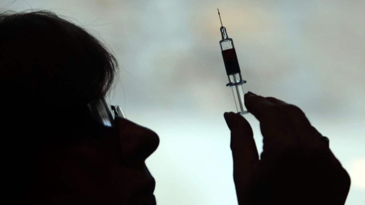 A health worker preparing to give a patient a vaccine.