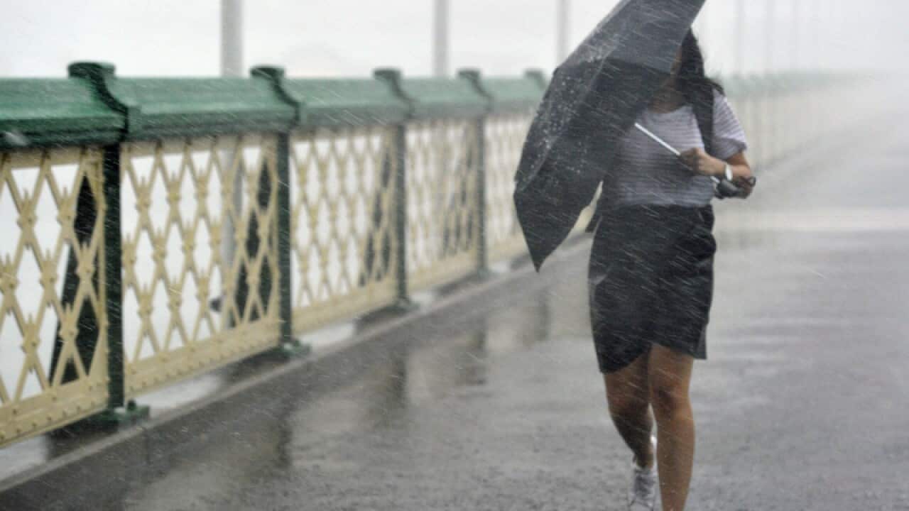 Pedestrians try to escape heavy rain in Sydney