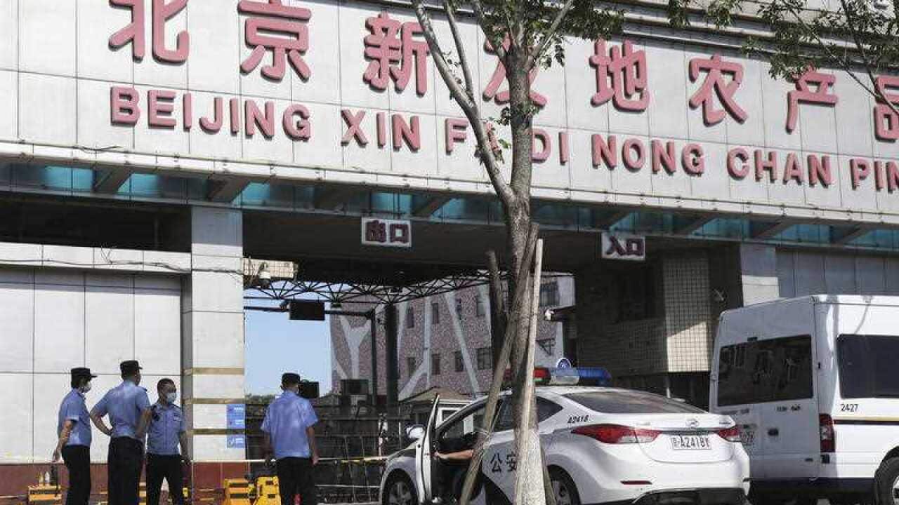 Police cars are parked at an entrance to the Xinfadi wholesale market, where a new coronavirus cluster has been reported.