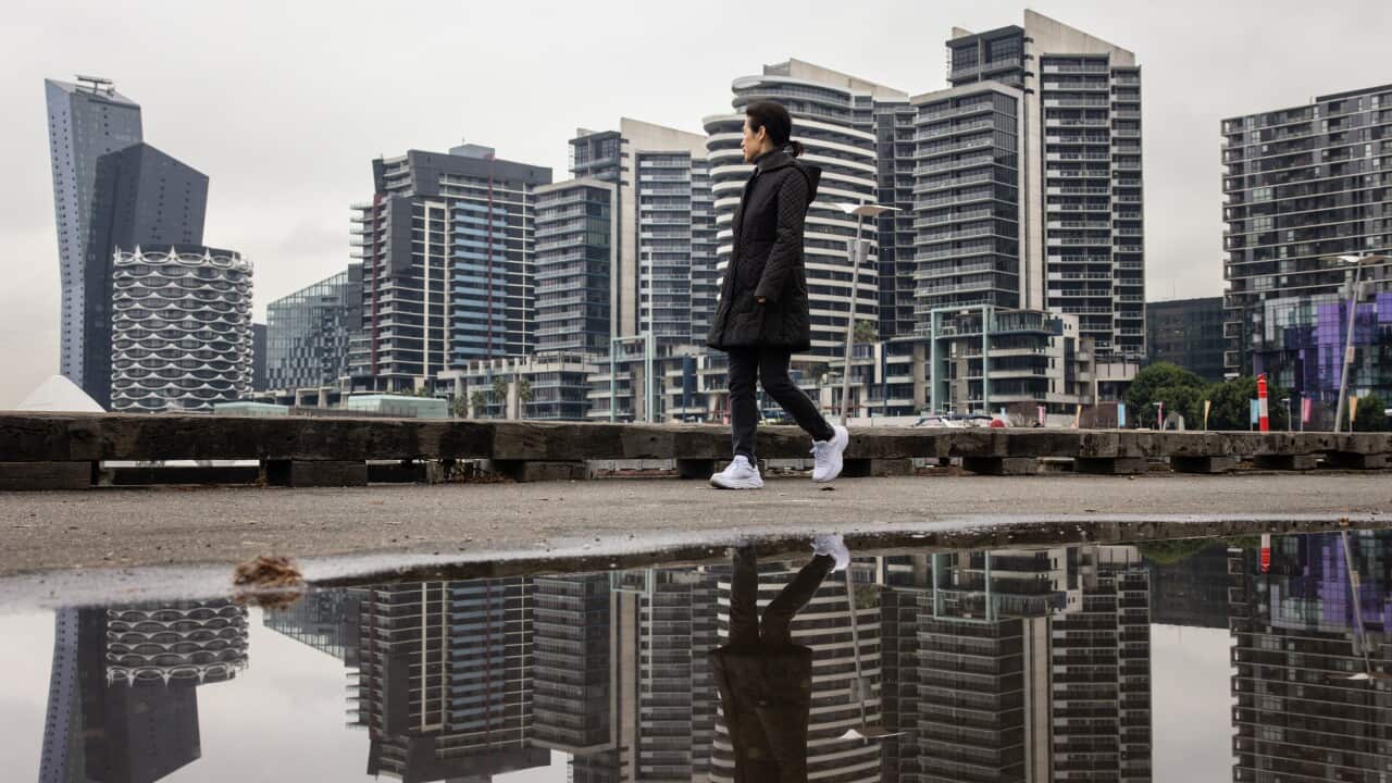 A woman walks along Dockland Harbour during a cold morning in Melbourne.