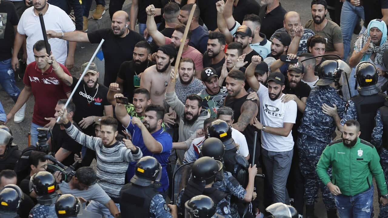 In this Oct. 29, 2019 file photo, riot police try to stop supporters of the Shiite Hezbollah group who arrived in the camp set up by anti-government protesters