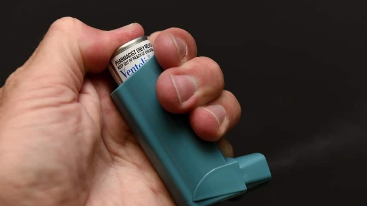 A person holds a canister of Ventolin