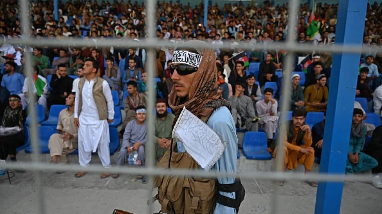 A Taliban fighter keeps vigil as spectators watch a Twenty20 cricket match in Kabul earlier this month.