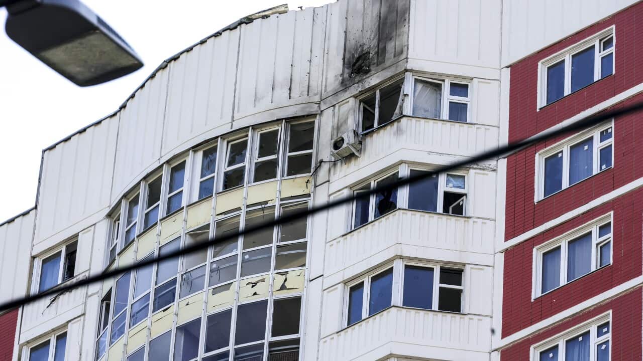 The side of an apartment building with damage caused by a drone