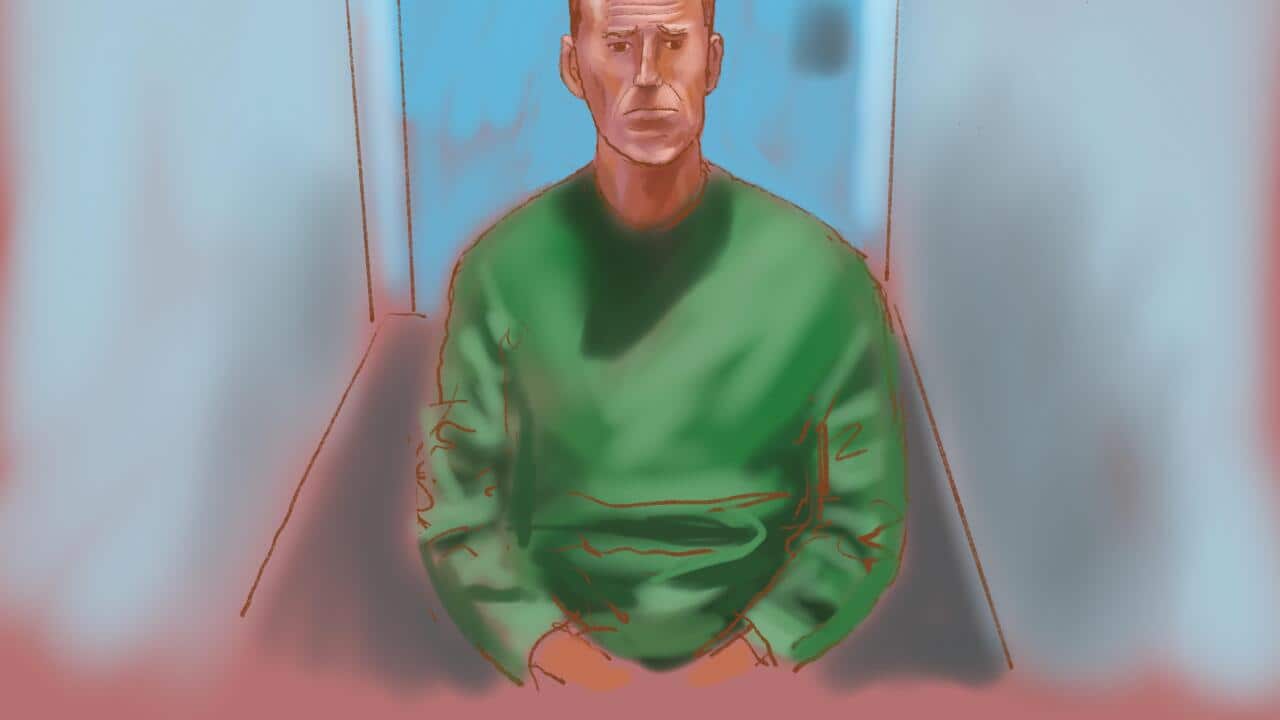A court sketch of a man wearing a green jumper sitting in a small room to appear in court via video link.