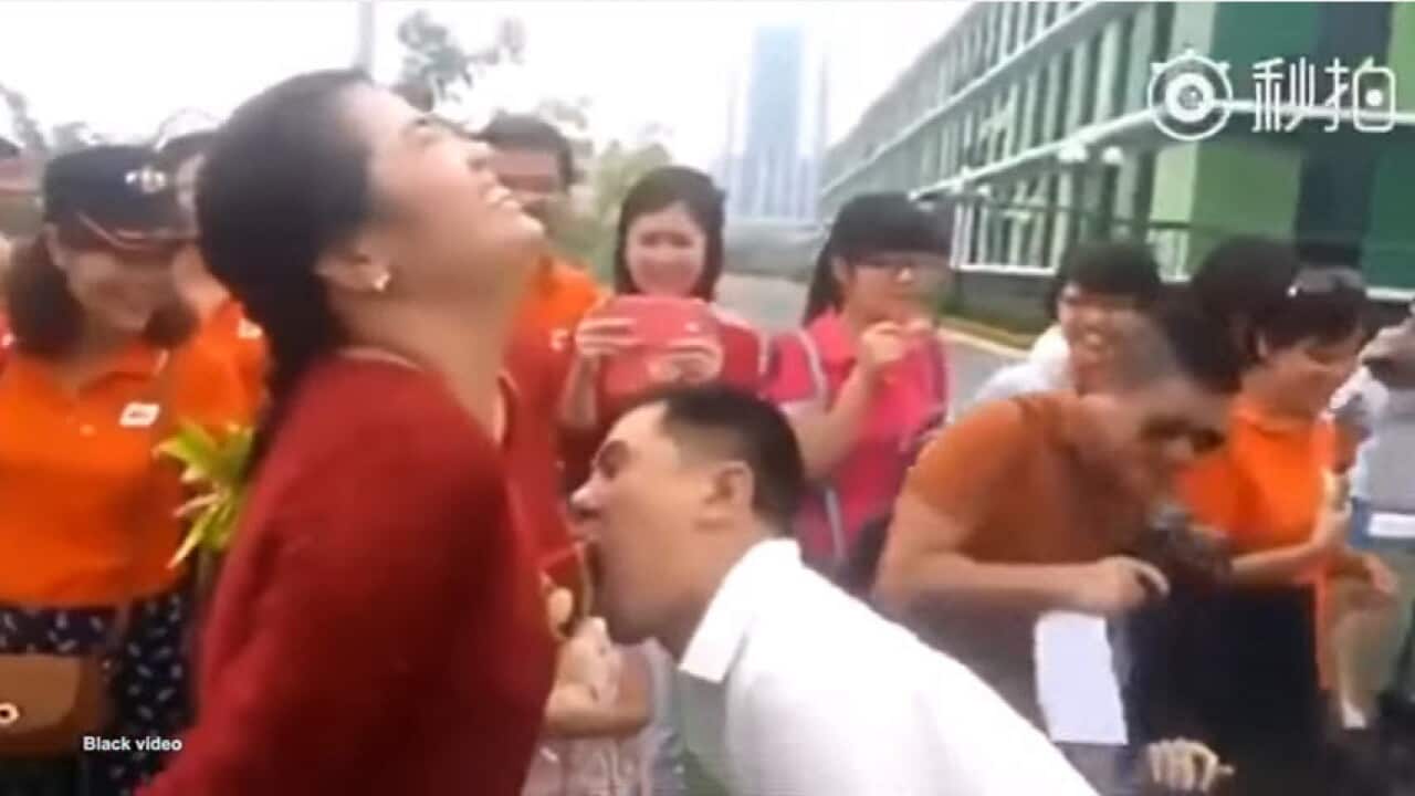 Male staff compete to eat grapes hung around female co workers' breasts