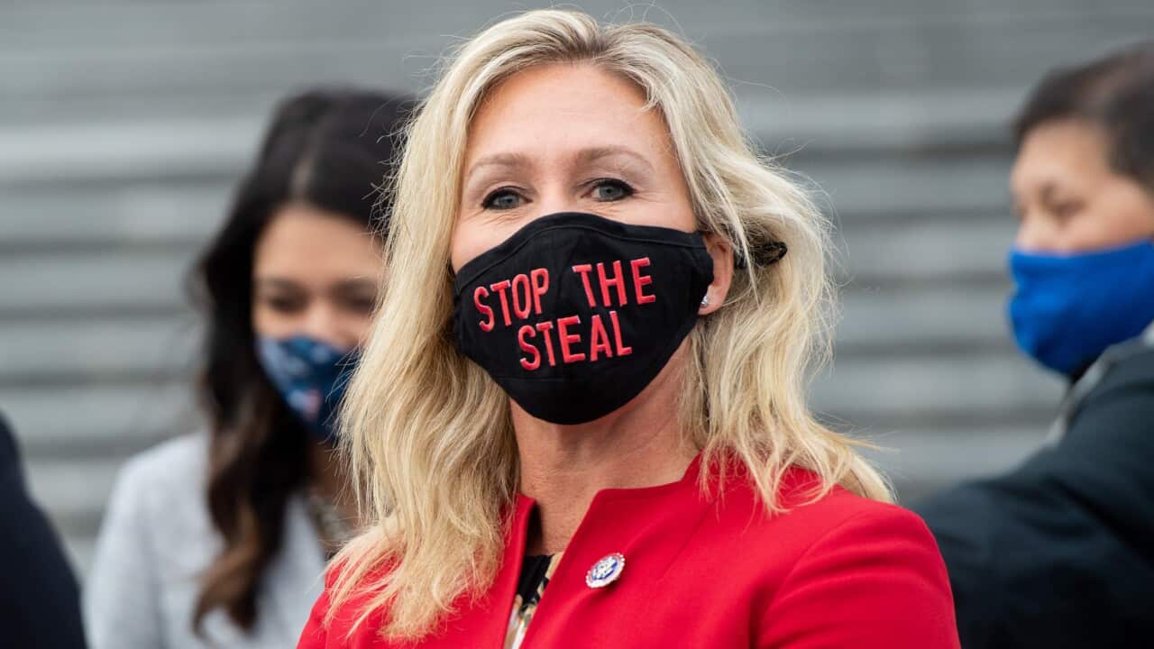 Marjorie Taylor Greene wears a "Stop the Steal" mask while speaking with fellow first-term Republican members of Congress at the US Capitol on 4 January.