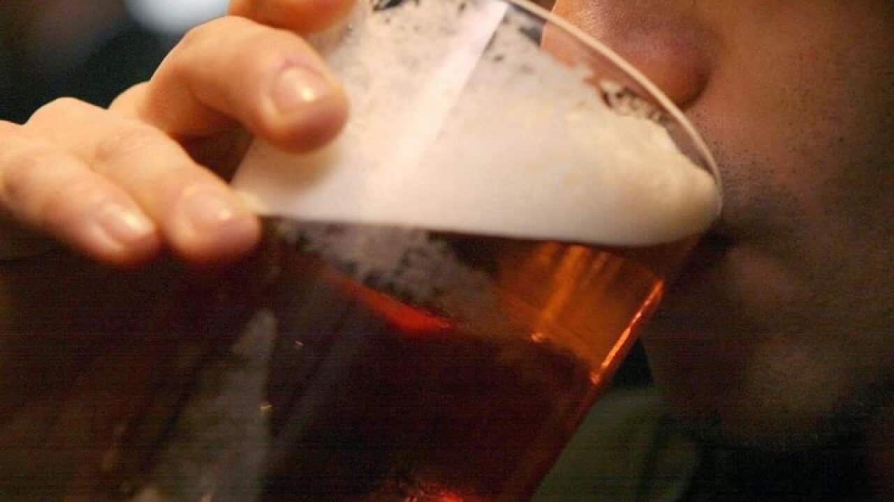 An adult drinking a beer