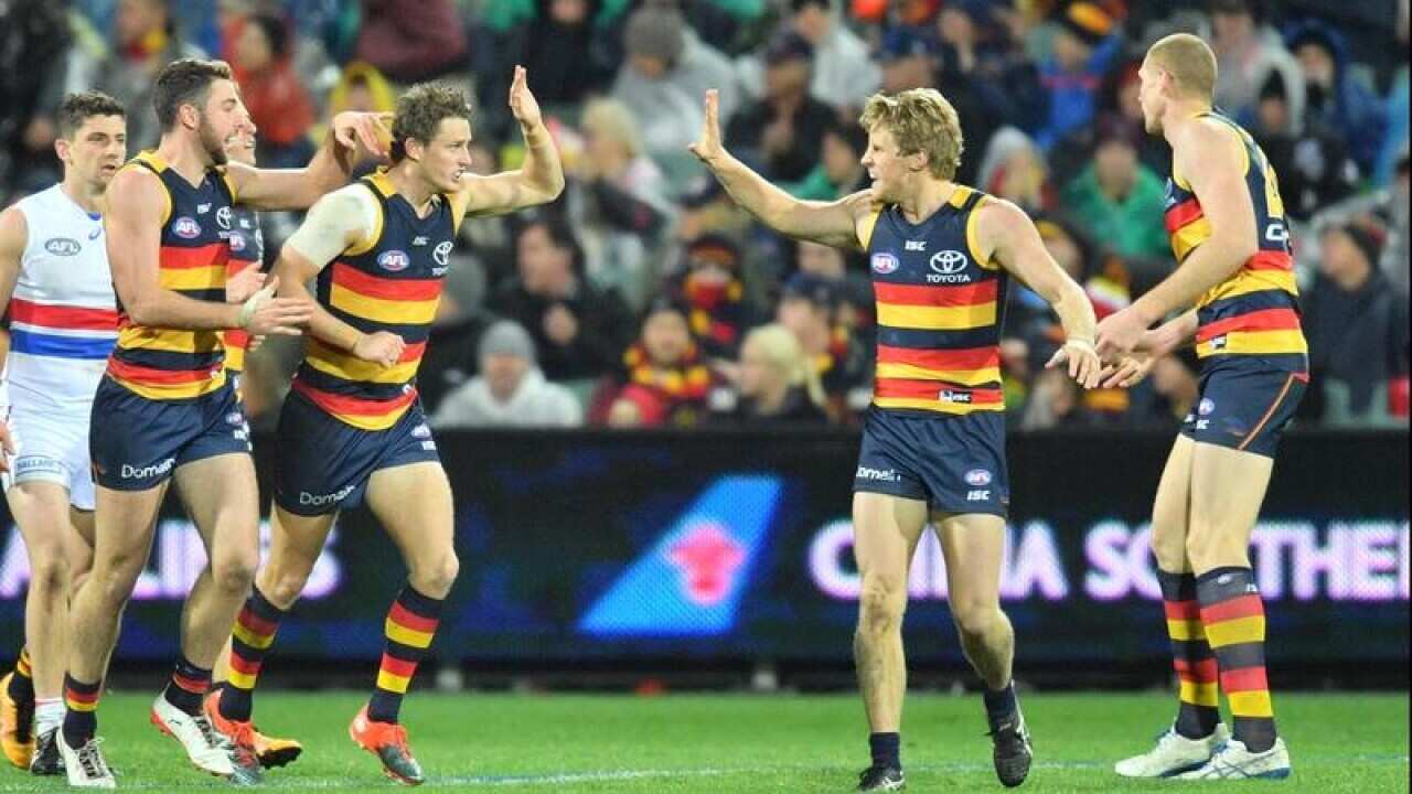 Crows players celebrate after scoring a goal