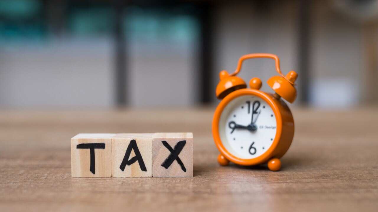 An orange clock and the word tax