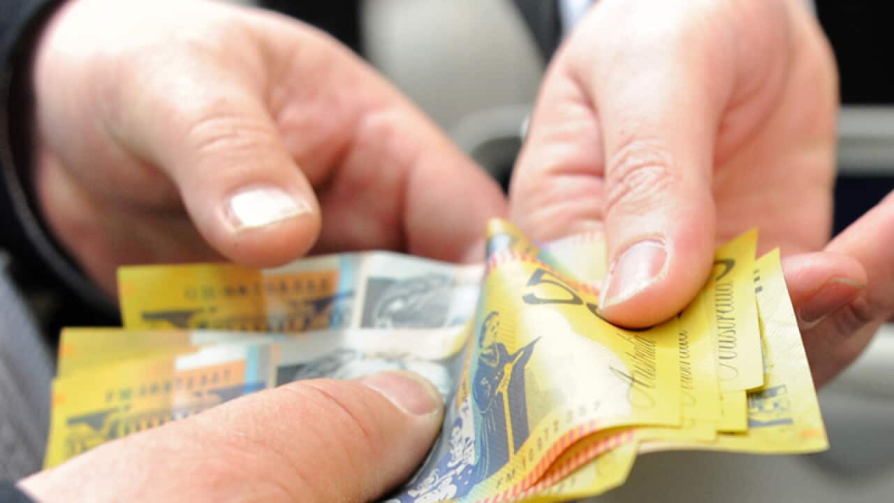 File photo of money changing hands