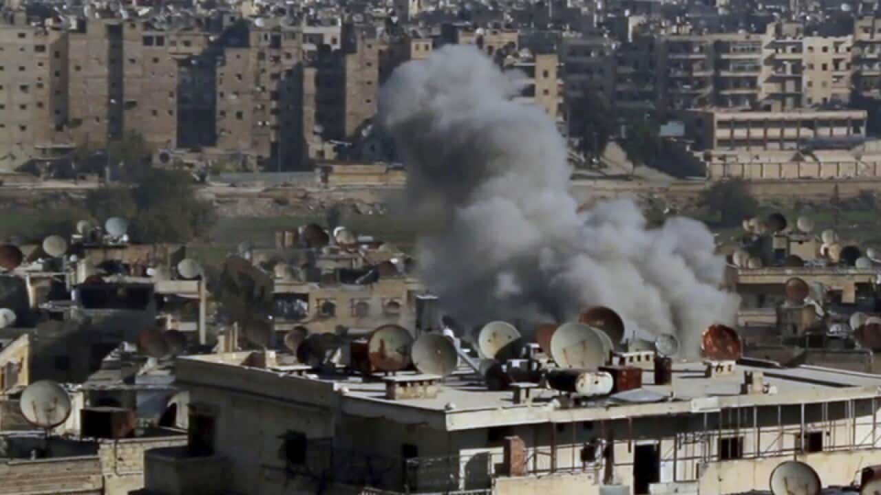 Shows smoke rising following an air strike in Aleppo
