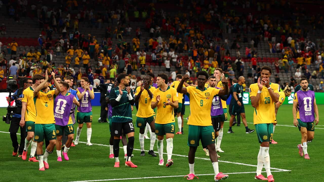 Football players in gold jerseys celebrating a win