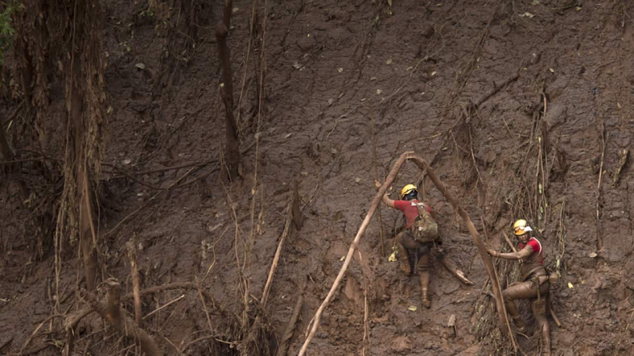 Rescue workers search for victims of a Brazilian mining accident