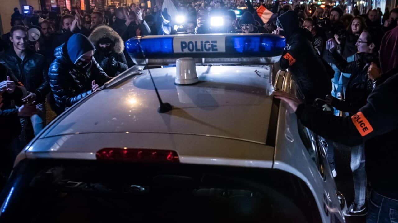 French police surround a police vehicle in Paris