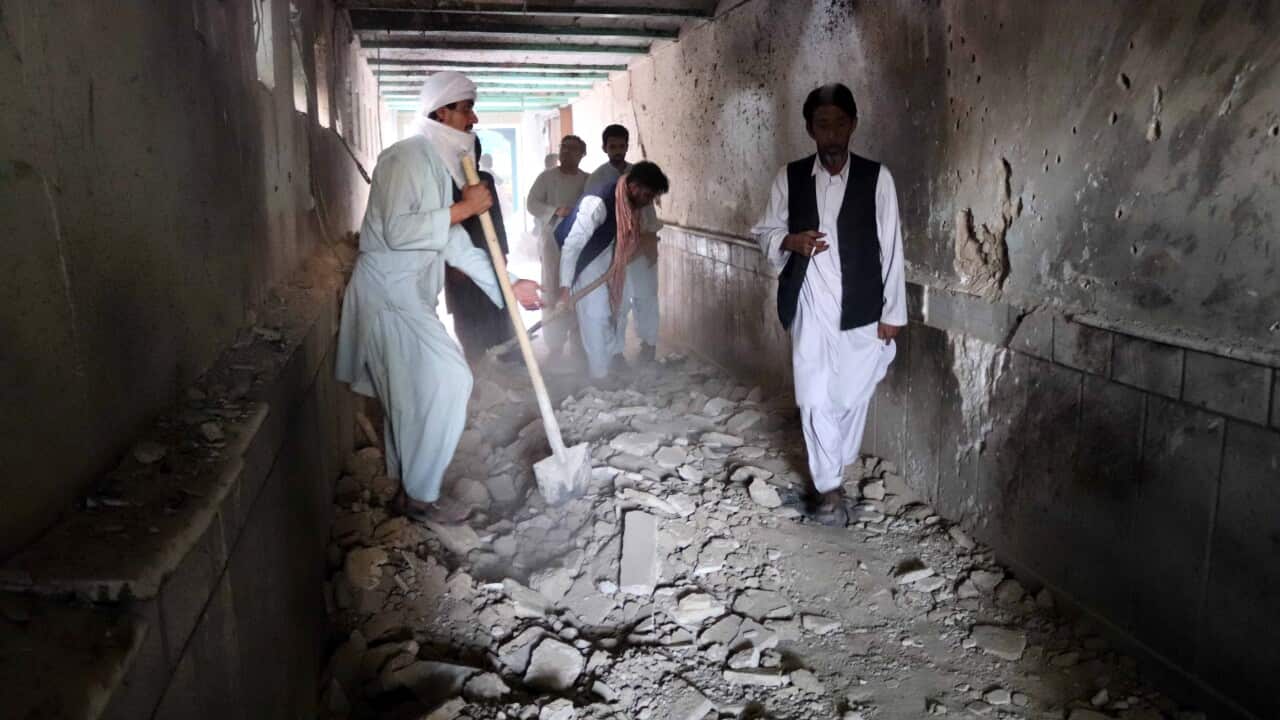 People inspect the scene of the blasts during Friday prayers at Imam Bargah mosque in Kandahar, Afghanistan, 15 October 2021