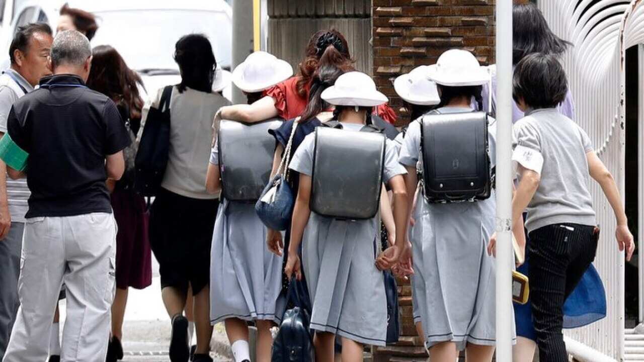 Students leave the CARITAS Elementary School in Kawasaki after a knife wielding man killed two people at a bus stop nearby.