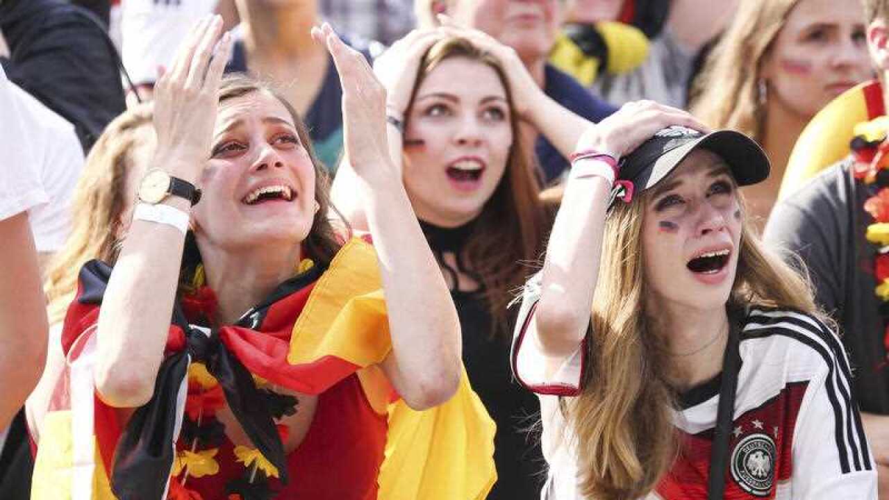 Soccer fans react after Germany was eliminated from the World Cup as they watch the group F World Cup match between South Korea and Germany.
