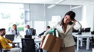 Mid adult businesswoman with cardboard box being fired