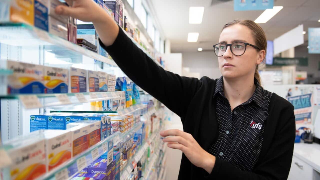A pharmacist reaches for medicine at a shop in Coburg, Melbourne (AAP)