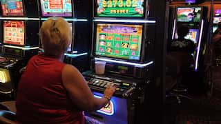 A woman sits at a colourful poker machine