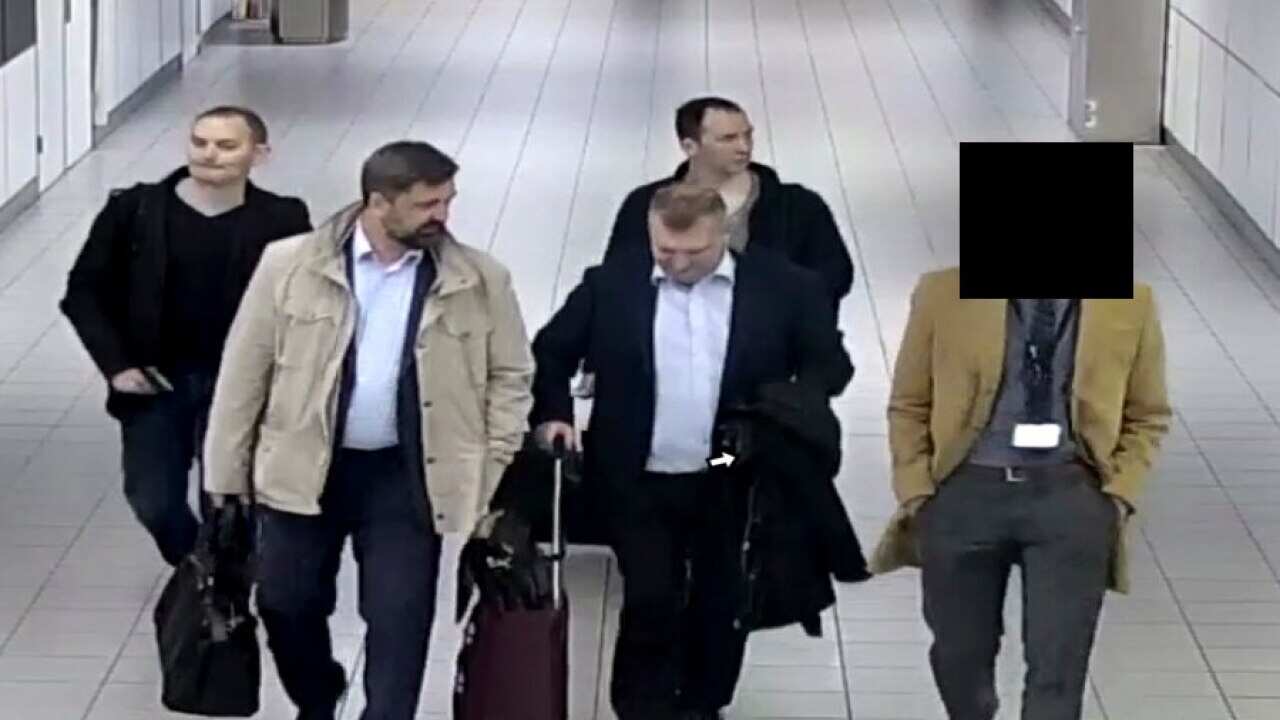 Four Russian officers of the GRU, are escorted to their flight after being expelled from the Netherlands in April