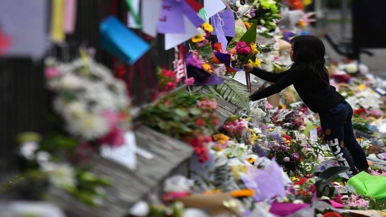A child places flowers at a makeshift memorial