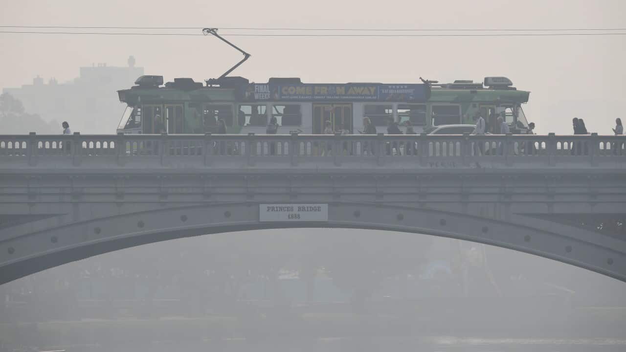 Morning commuters are seen through smoke haze from bushfires in Melbourne.