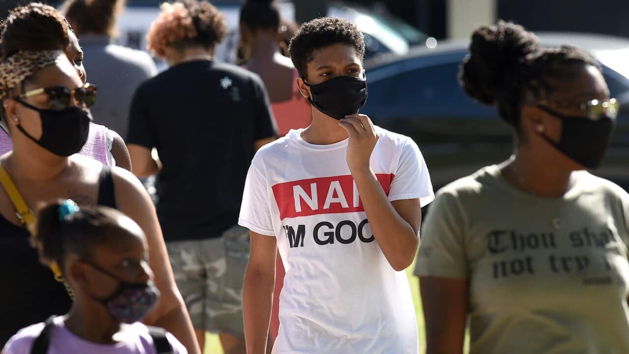 A family wearing face masks as a preventive measure during a walk at Orlando's Lake Eola Park in Florida.