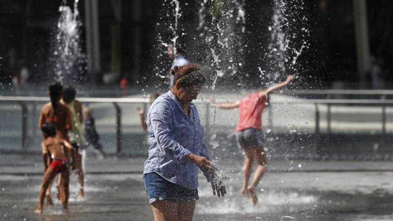 A woman refreshes at a fountain in Milan, Italy, Thursday, Aug. 2, 2018. Hot air from Africa is bringing a new heatwave to Europe, prompting health warnings.