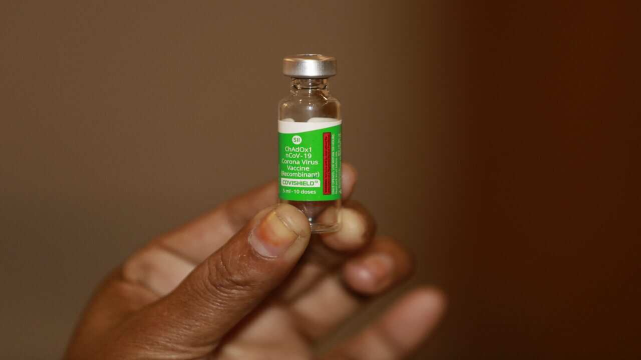 A health worker holds an Oxford-Astrazeneca developed vaccine produced by the Serum Institute of India (SII).