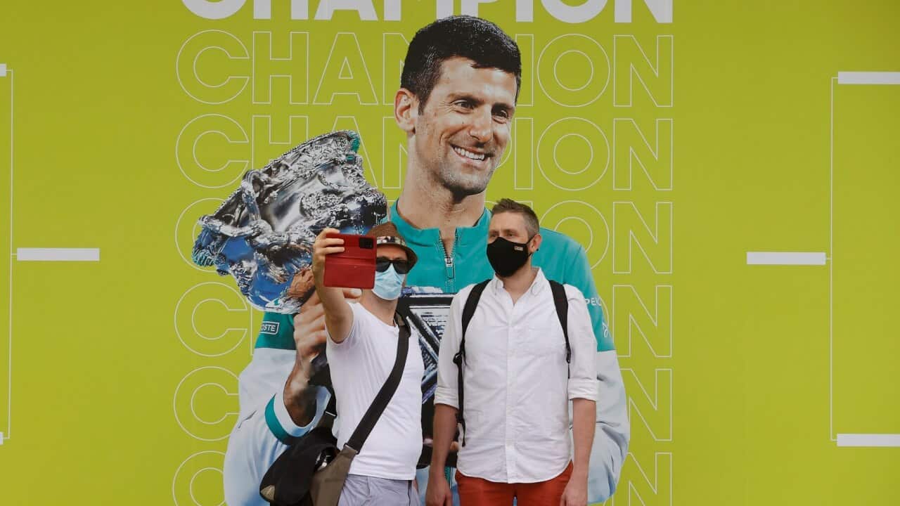 People take a selfie with a photo of Novak Djokovic at the Australian Open tennis championships in Melbourne