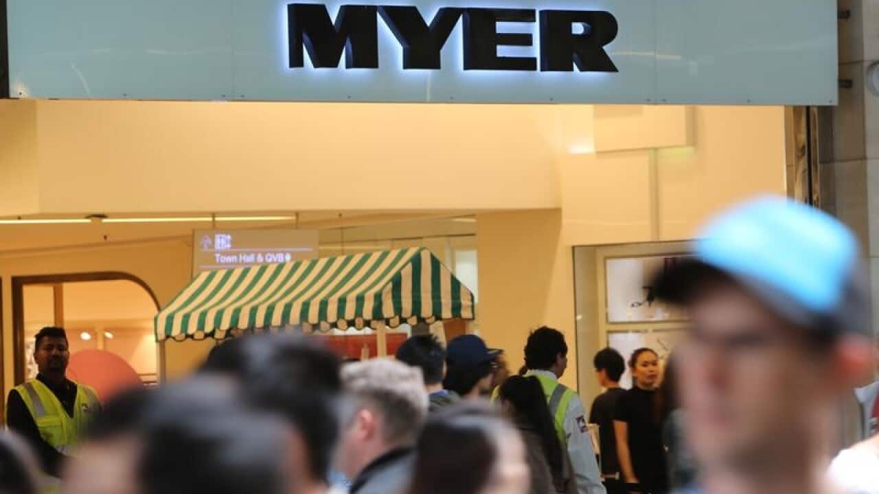 Shoppers walk past a Myer department store.