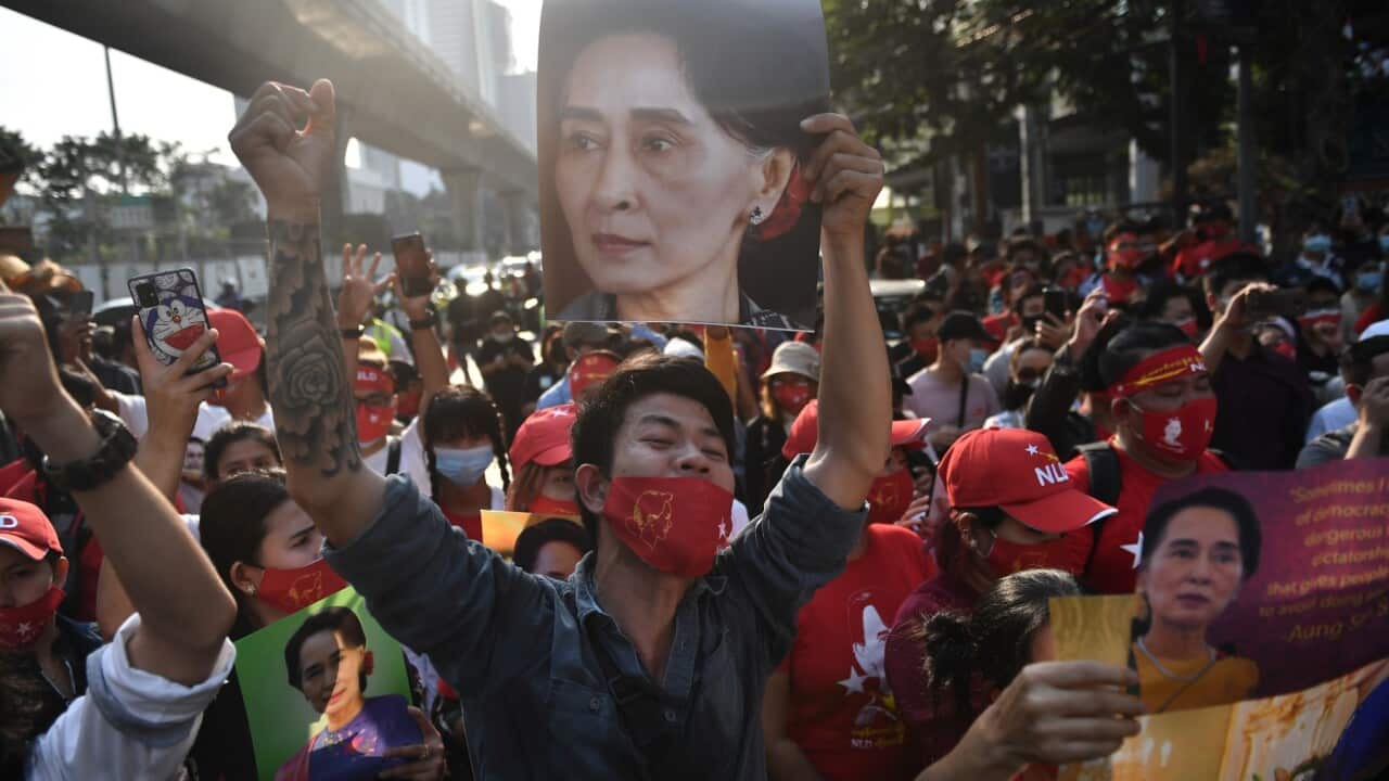 Myanmar migrants hold up portraits of Aung San Suu Kyi as they take part in a demonstration outside the Myanmar embassy in Bangkok on February 1, 2021.