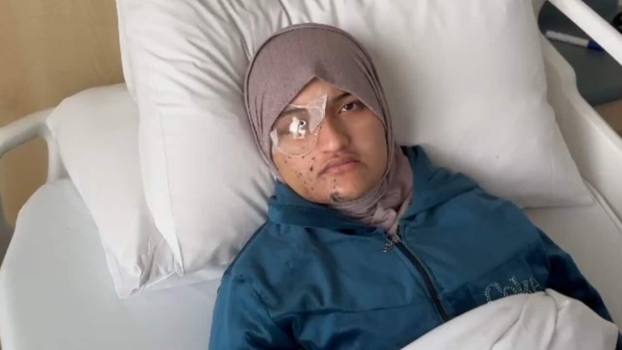 A woman with an eye patch over her right eye laying in a hospital bed.