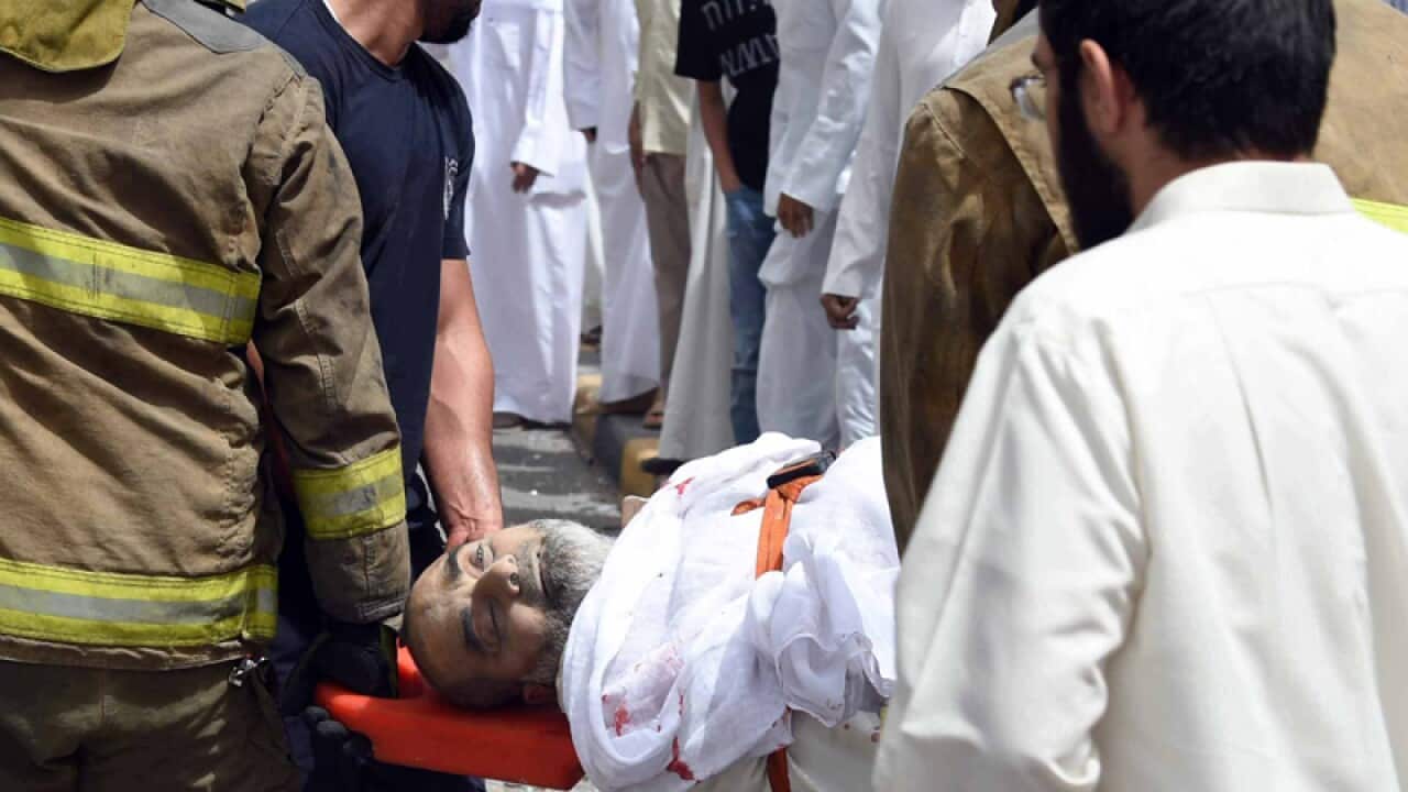 A wounded man is helped after an explosion in Kuwait