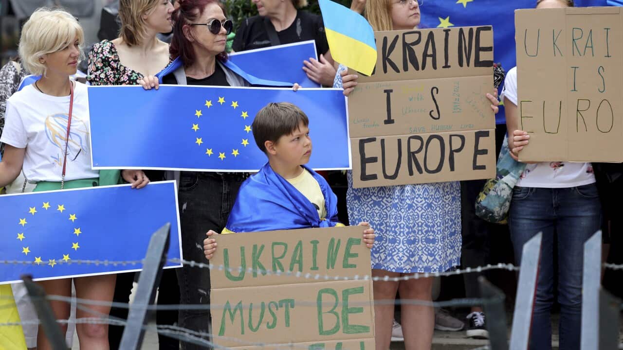 Protestors in support of Ukraine stand with signs and EU flags during a demonstration outside of an EU summit in Brussels.