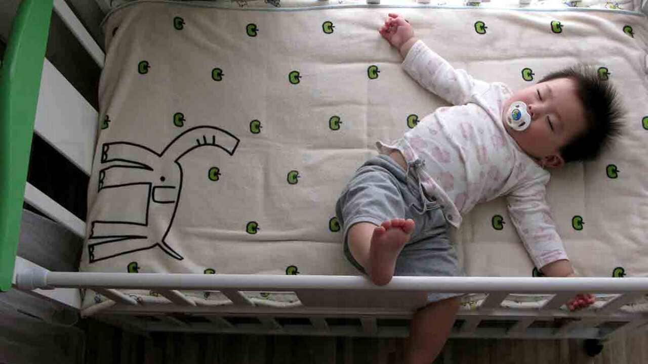 Baby lying in a cot