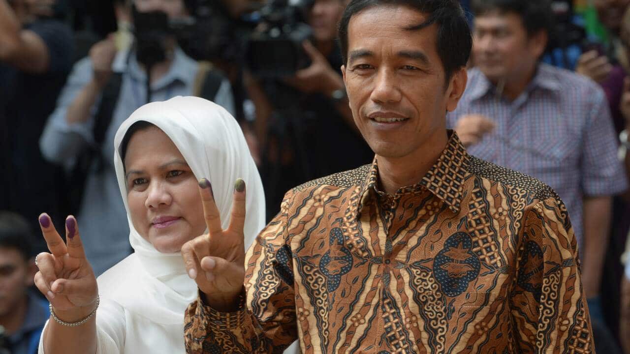 Indonesian presidential candidate Joko Widodo (R) and his wife Iriana Widodo (L) gestures after voting at a polling centre in Jakarta (AFP).