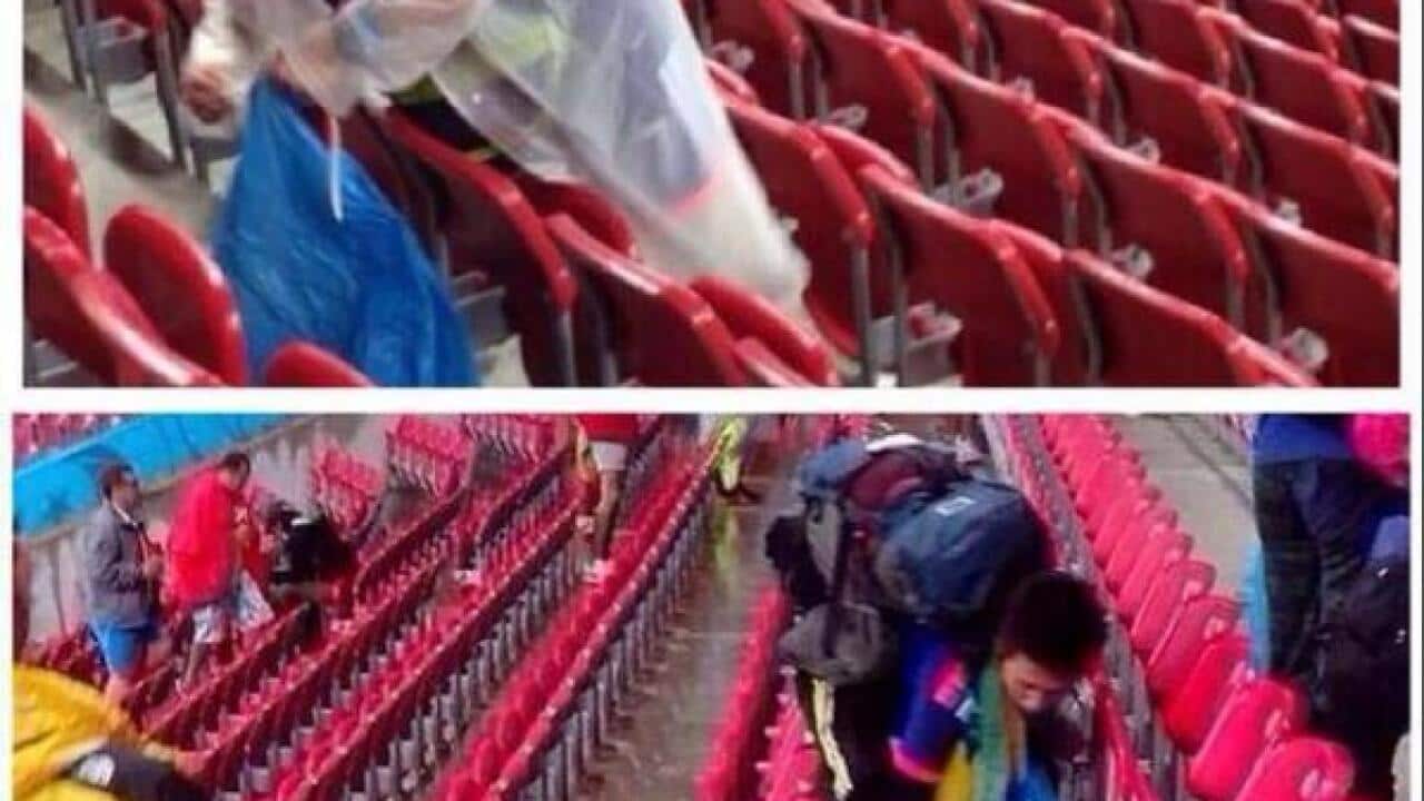 ‏Japanese fans clean their part of the stadium yesterday after their defeat to the Ivory Coast. (Picture via @2014WC_Brazil)
