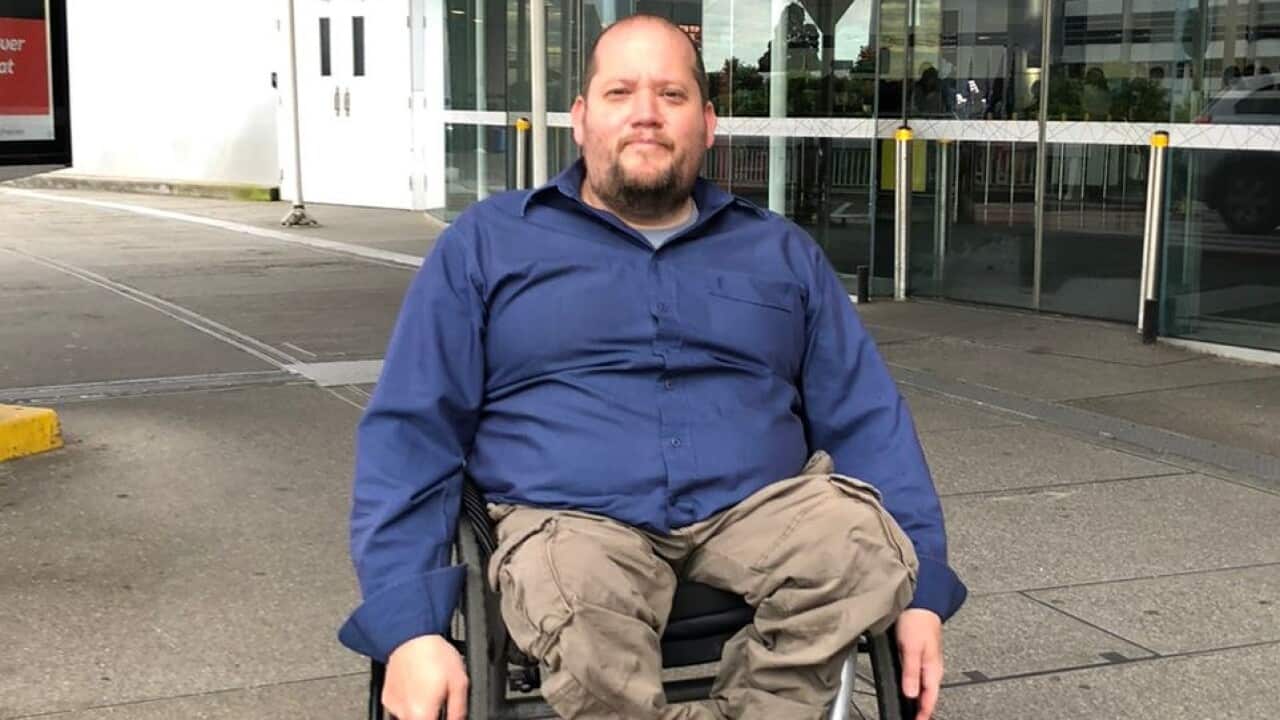 A man in a wheelchair out the front of Melbourne airport.