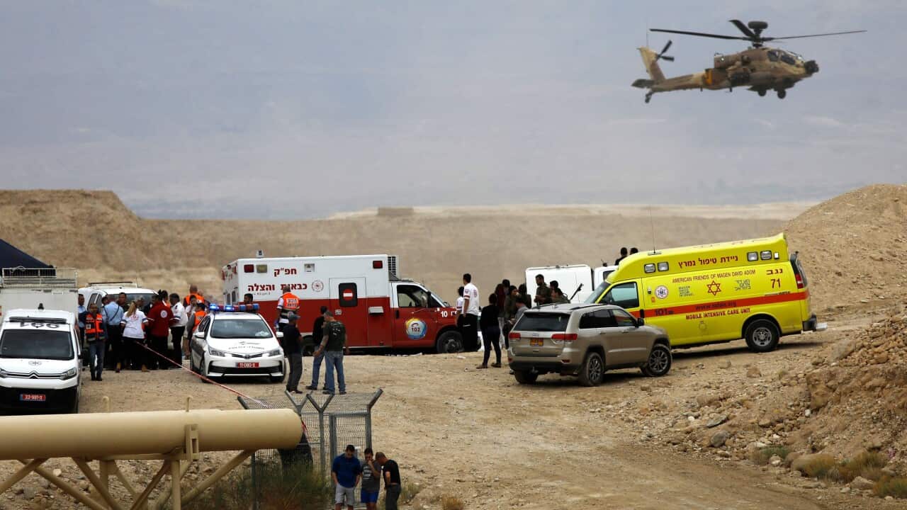 Israeli emergency services take part in a search mission for several young people missing near Arava in southern Israel after flash floods swept through the area.