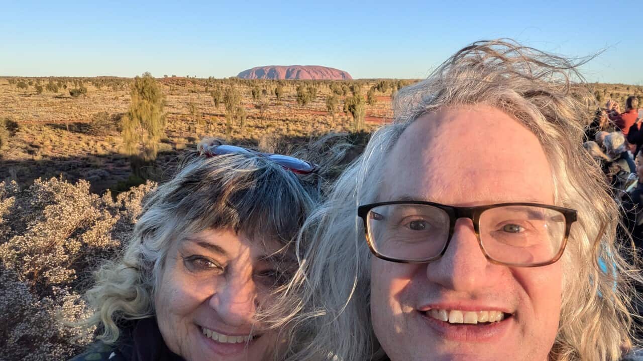A woman and a man in front of Uluṟu