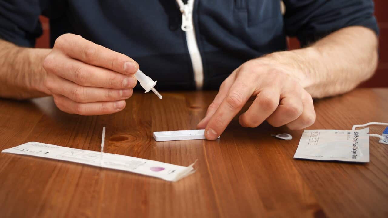 Man conducts a rapid antigen test at home.