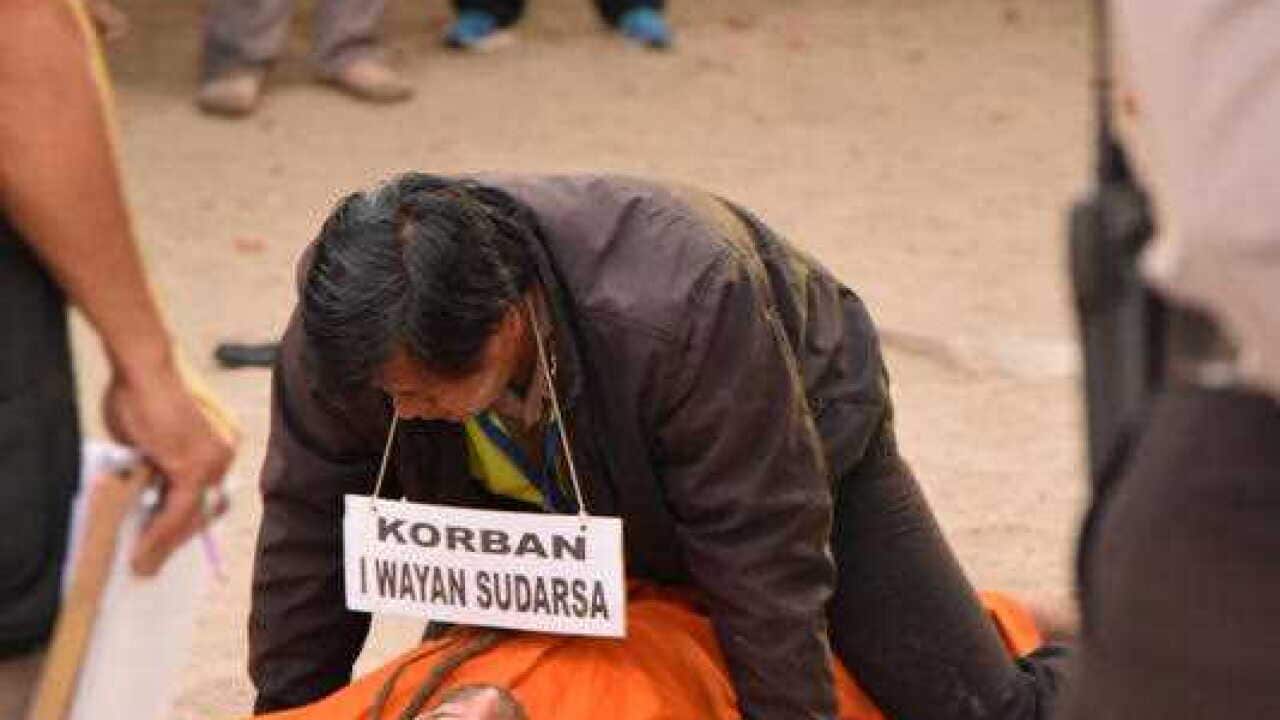 British man David Taylor reenacts a scene on Kuta beach with a police officer posing as alleged murder victim Wayan Sudarsa, Kuta Beach, Bali