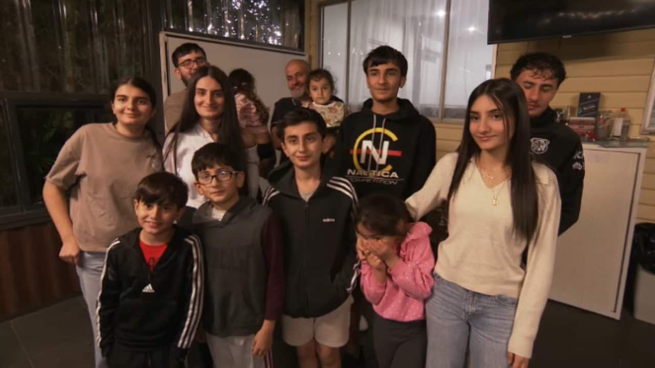 A group of thirteen people and children of different ages.
