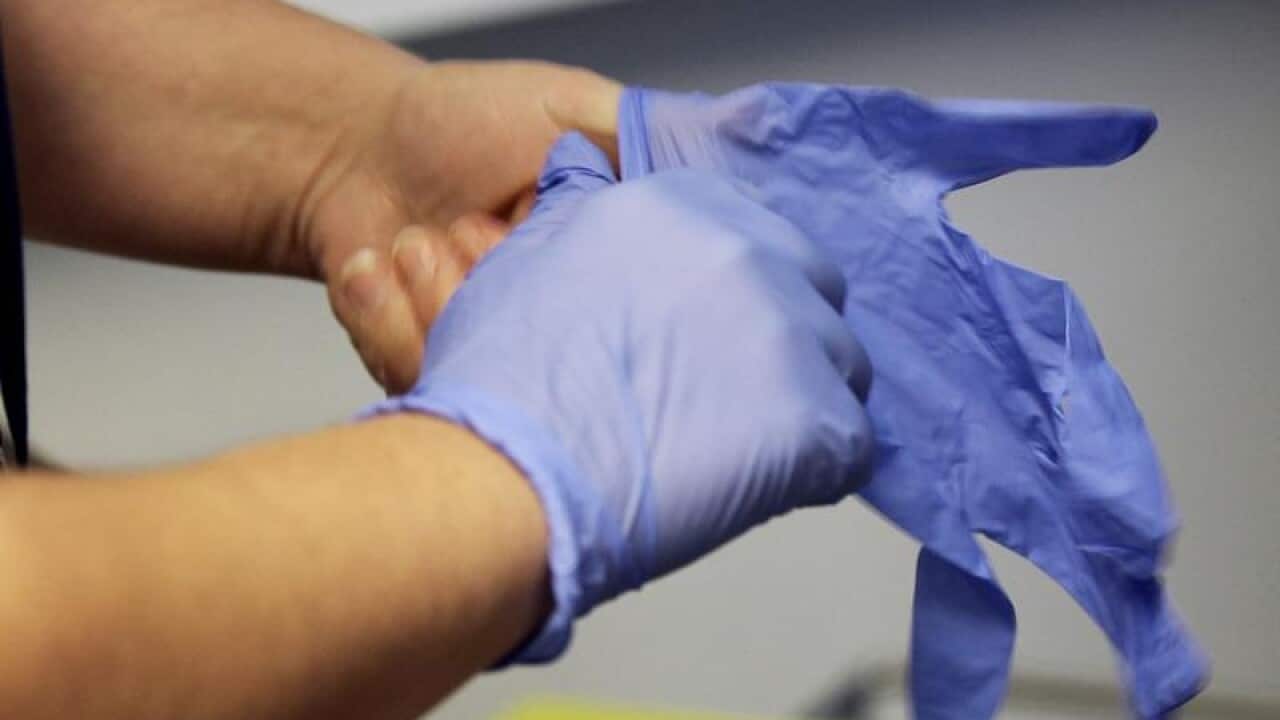 A man wearing latex gloves