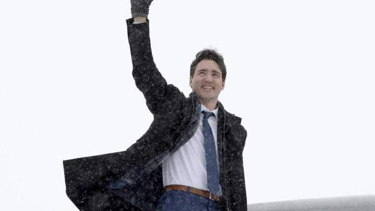Prime Minister Justin Trudeau waves as he boards the government airplane on his way to Chicago, in Ottawa on Wednesday, February 7, 2018.